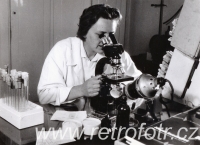 Žena nad mikroskopem